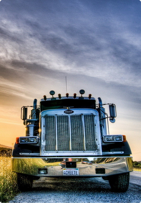 Chrome-grille truck parked roadside at sunset